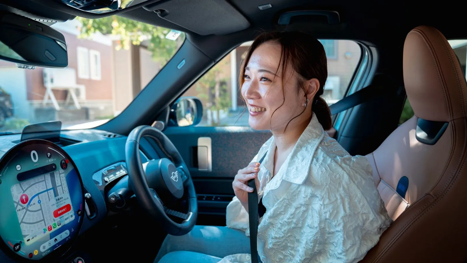 運転席で笑顔を見せる女性